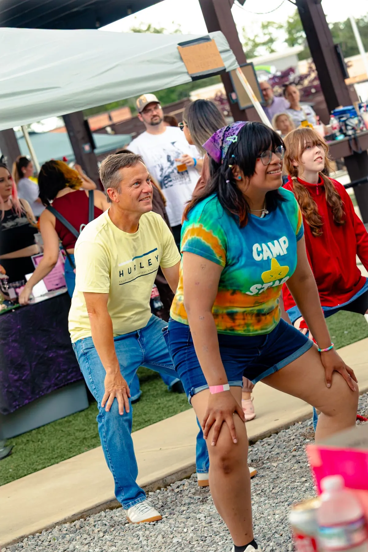 Two dancers mid-lunge learning choreography at an outdoor Knox Pop Con dance class